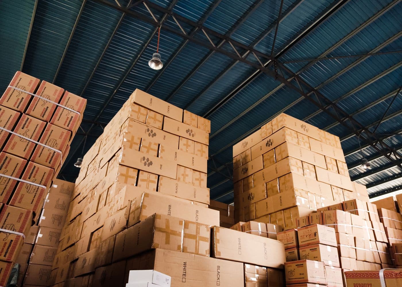 Stacked cartons and palletised household goods inside a clean storage warehouse