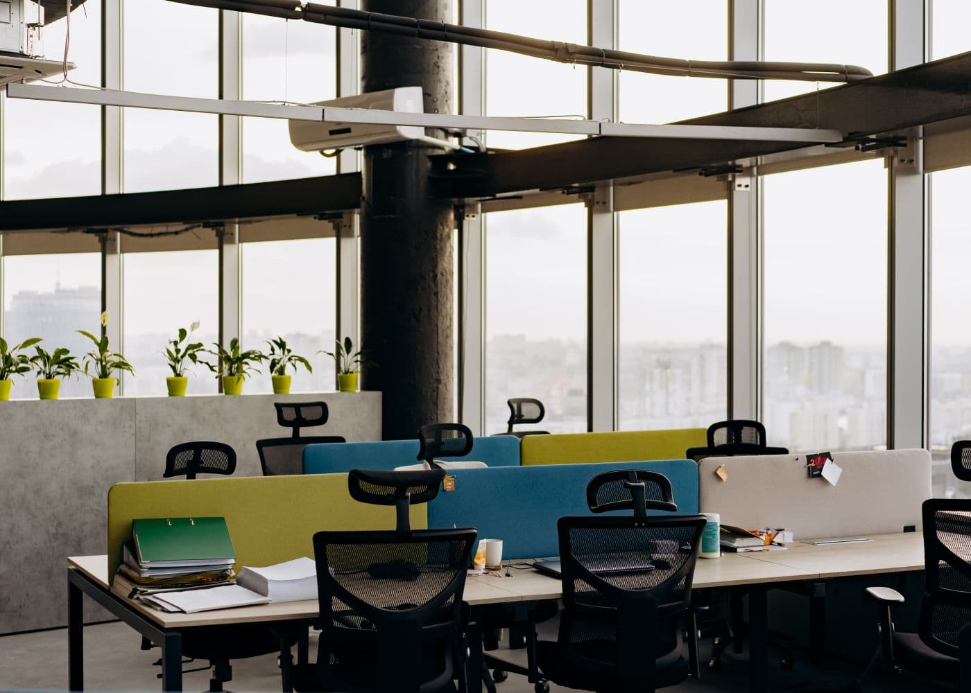 Open-plan office workstations beside floor-to-ceiling windows, ready for relocation